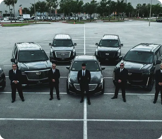 An aerial view of a fleet of black luxury Cadillac Escalade SUVs and sedans arranged in a formation in a parking lot, with a team of professional security personnel in black suits and sunglasses standing formally in front of each vehicle.