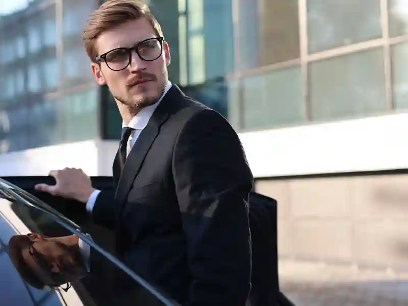 Man in a black suit and glasses is waiting to get inside the black Mercedes-Benz black colour