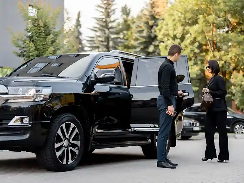 A woman getting off the chauffeur service car