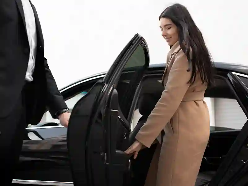 A woman getting in the back of the car
