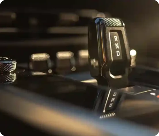 A close-up of a sleek black automatic gear shifter with illuminated indicators, featured on the Starr Luxury website.