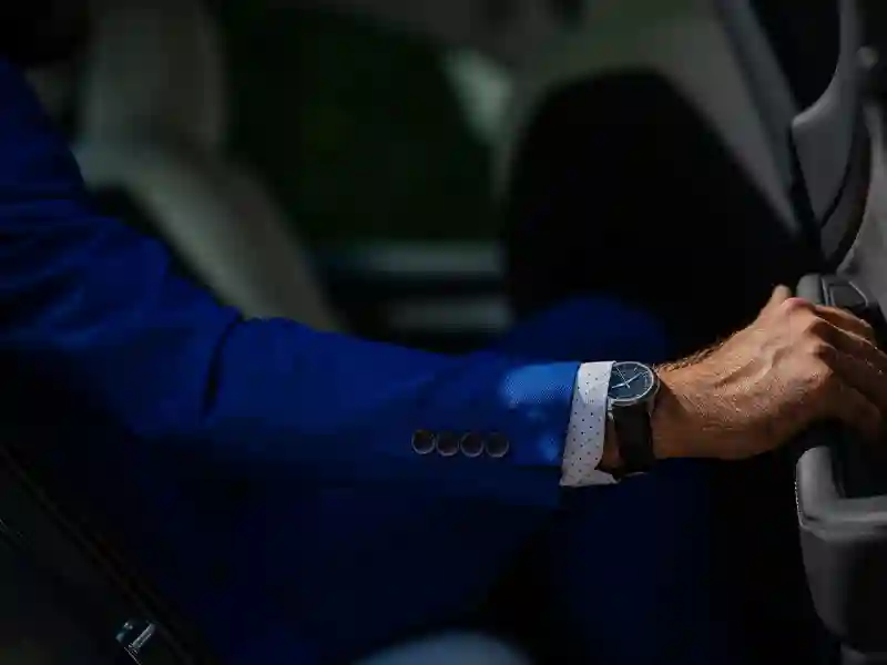 A close-up of an arm of a man who wears a light blue suit