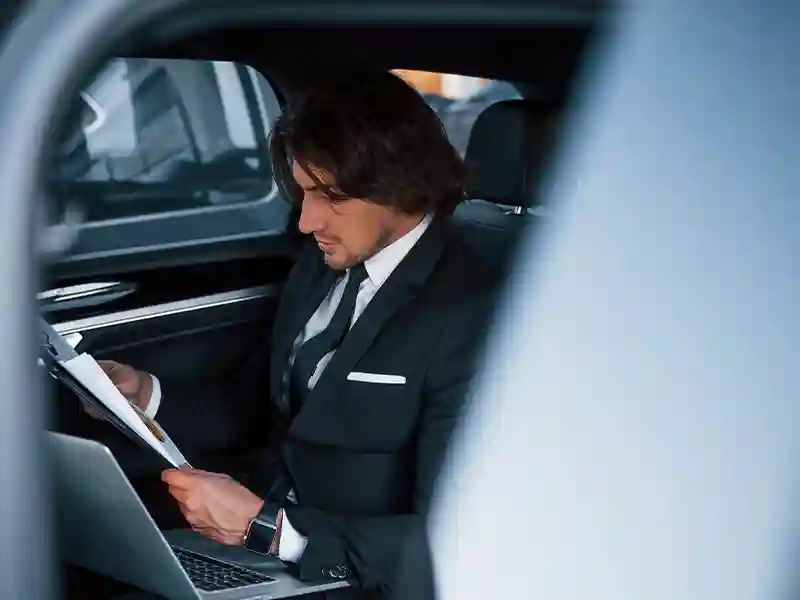 Man in suit on the back seat making annotations for his next client