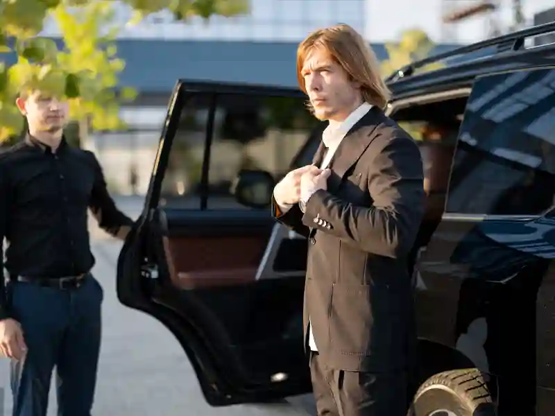 Chauffeur opening the door for man in grey suite