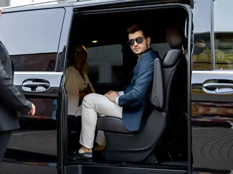 Mercedes-Benz V Class, with the door opened by the chauffeur, a couple inside is waiting to get out of the car.