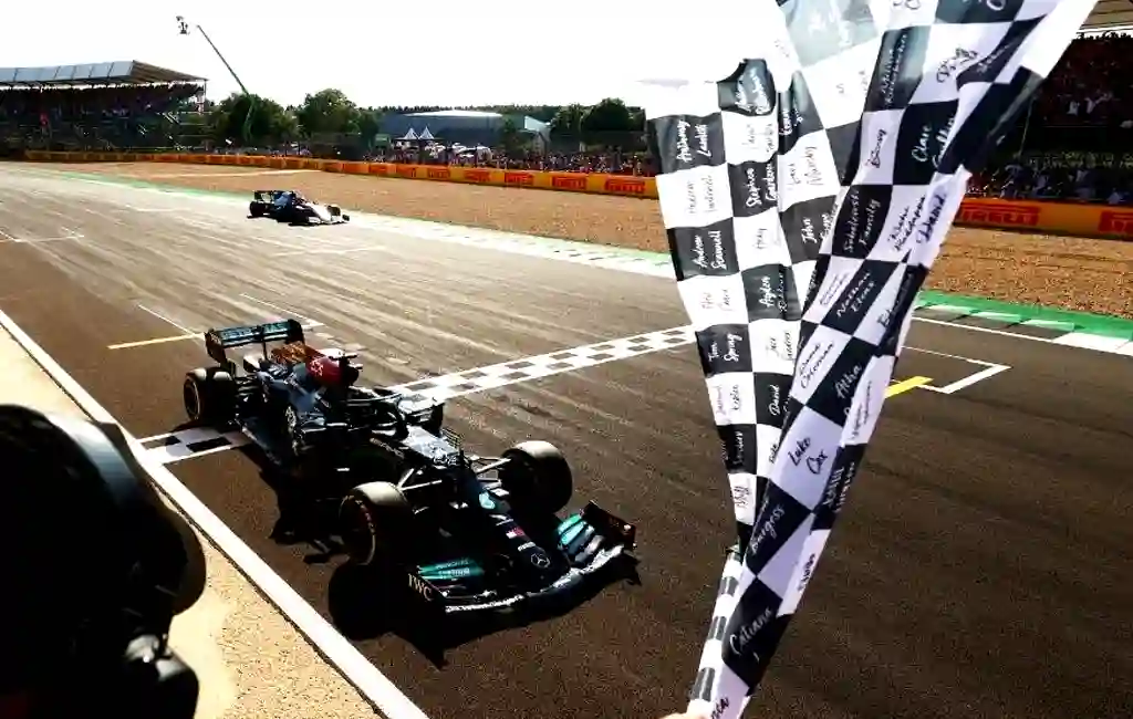 Formula 1 car in black color and crossing the flag spot