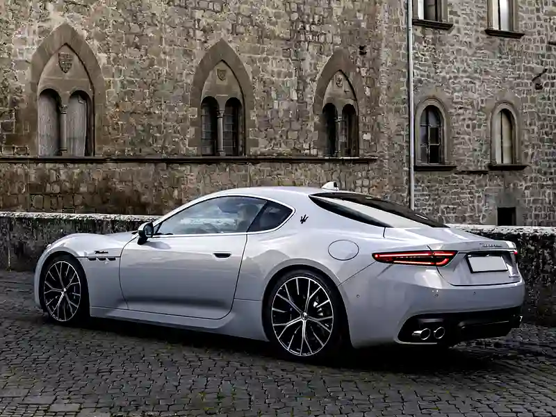 Maserati white outisde of an old building